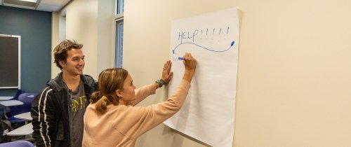 Centre students writing help on a poster